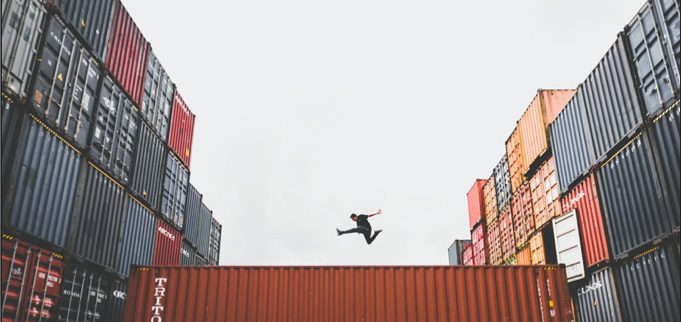Stacked shipping containers in a busy container yard